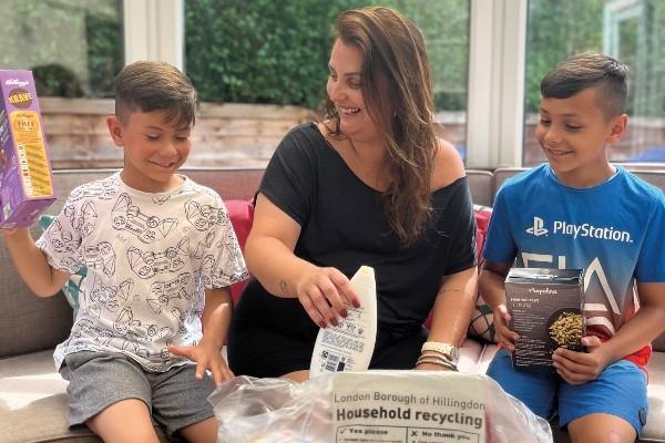 A woman and two young children sort recycling into a Hillingdon recycling bag