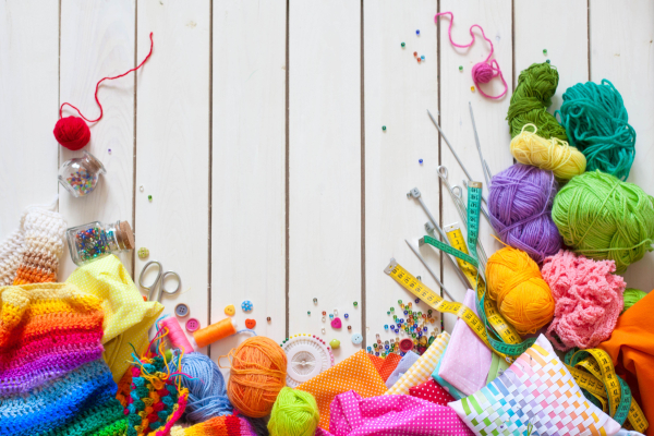 Colourful balls of wool and various knitting tools.