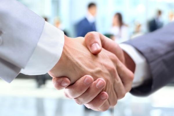 Two people shaking hands in smart work attire
