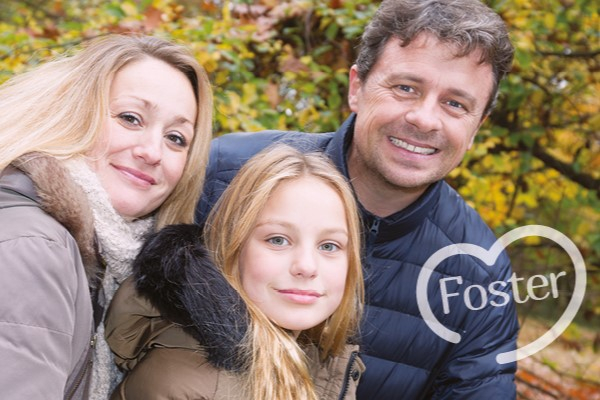 Photo of a couple with a teenage girl, all smiling at the camera