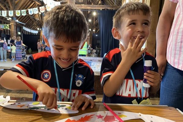 Two young boys smiling and laughing while crafting