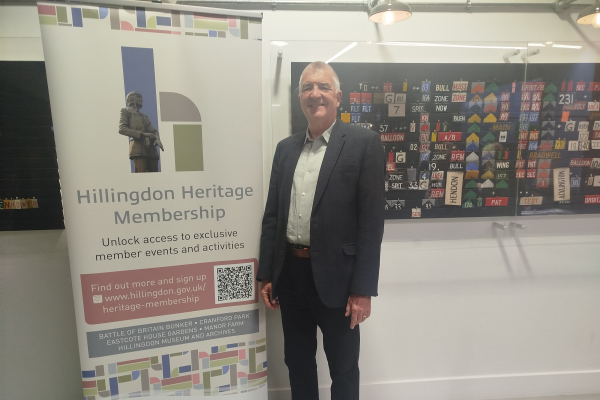 Cllr Eddie Lavery next to the Heritage Membership pull-up banner at the Battle of Britain Bunker