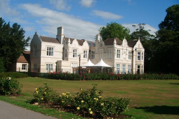 External view of Barra Hall main building with blue sky behind and flower beds in foreground
