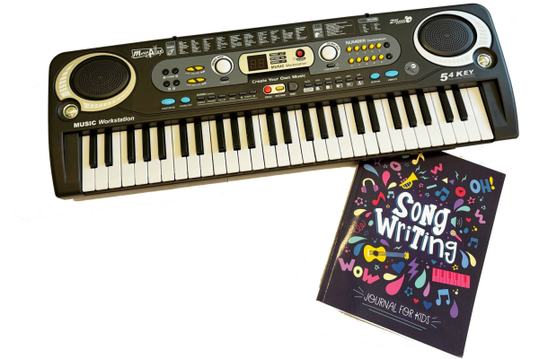 Photo of electronic keyboard and song writing journal