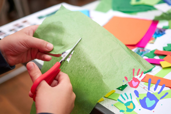 Child cutting paper with safety scissors