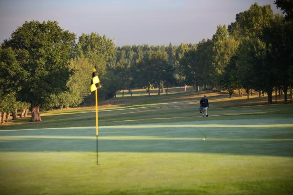 General view of Uxbridge Golf Course with a green in the foreground and a player approaching down the fairway