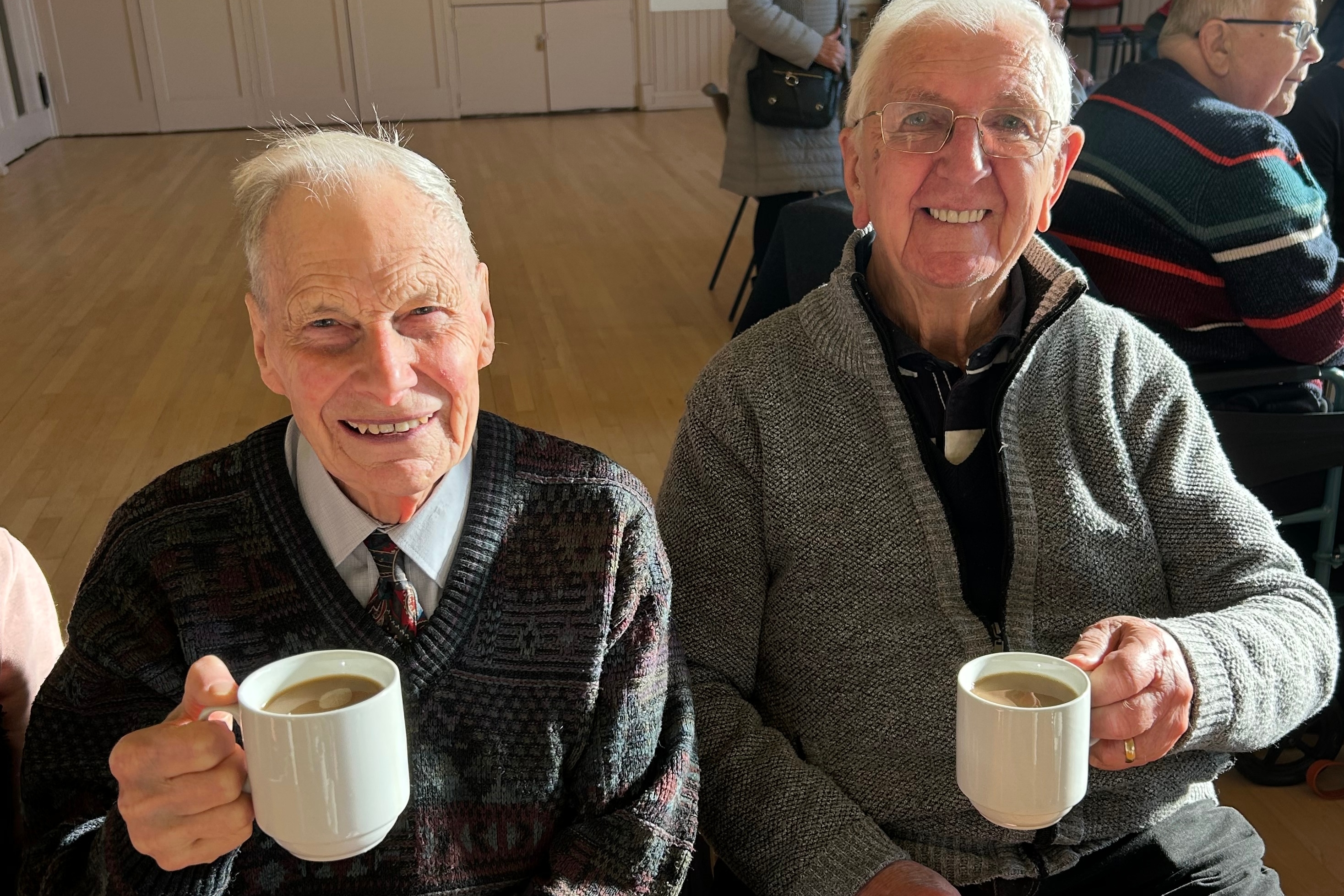 Image of two people holding hot drinks