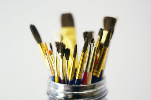 Photo of lots of different sized paint brushes in a jar
